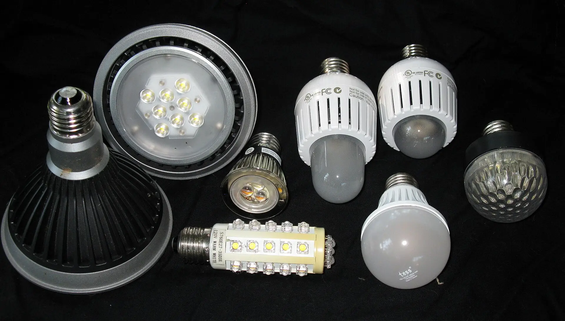 Several LED light bulbs of different shapes on a black background