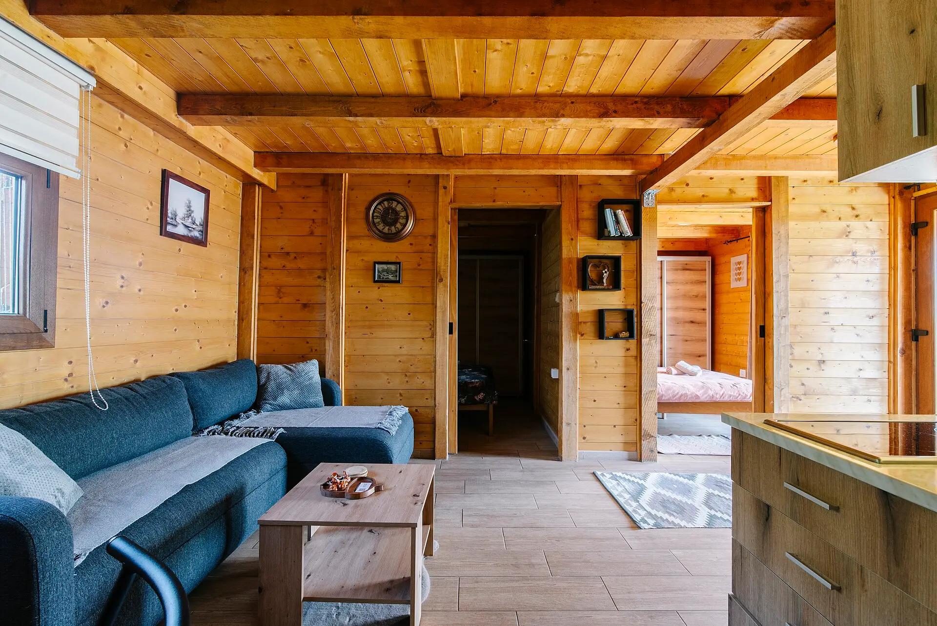 A wood-paneled cabin living room with a gray sofa