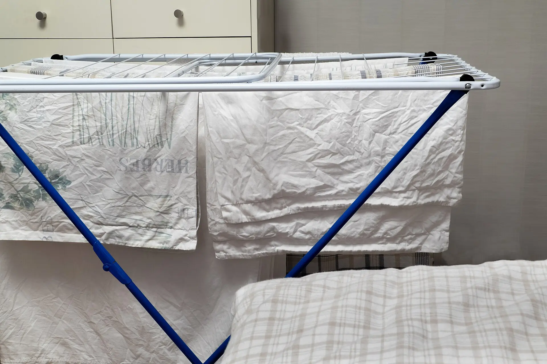 White laundry hanging on a folding drying rack